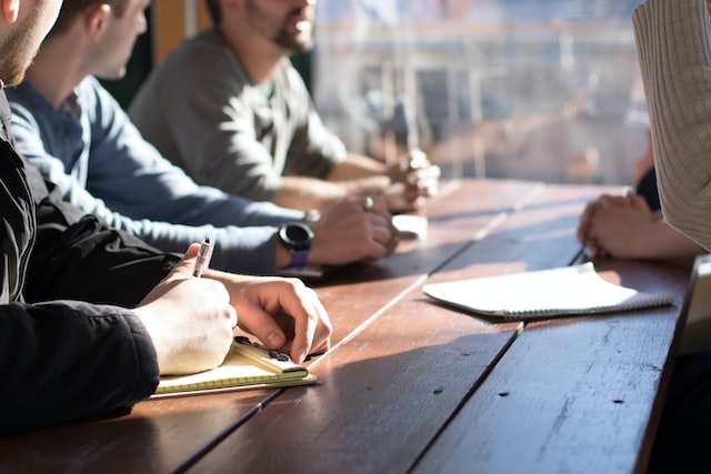 Cropped image of four people around a table in an office